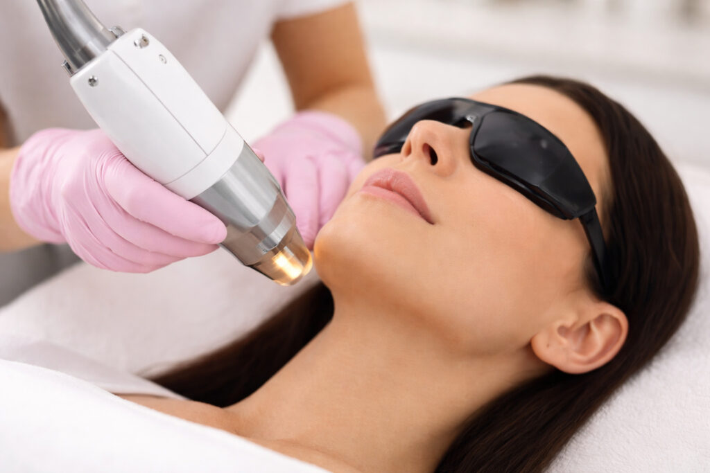 Laser technician performing skin treatment using professional laser equipment with safety protocols, highlighting importance of laser technician certification